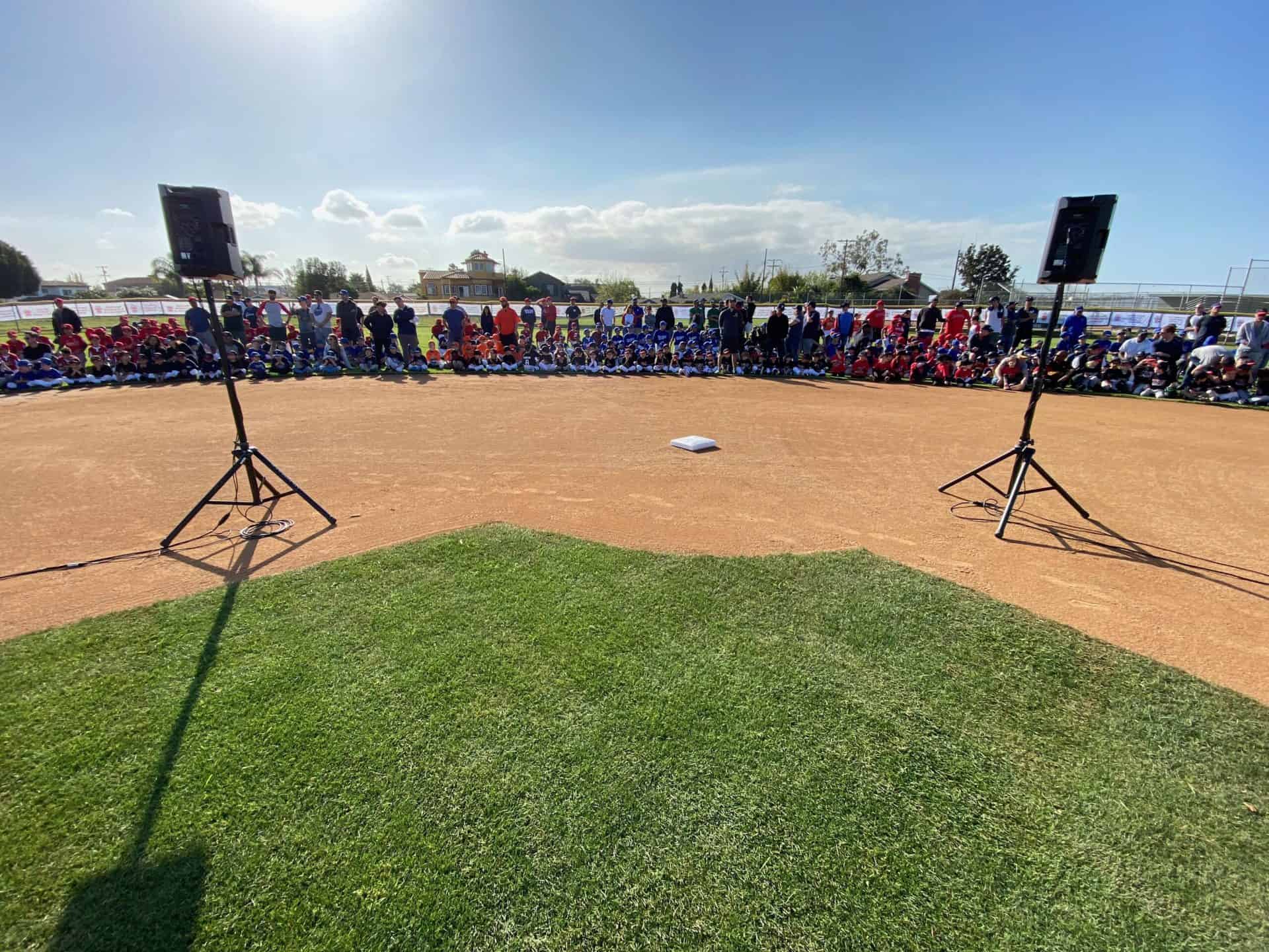 Young baseball players listening to speakers on opening day in San Jose