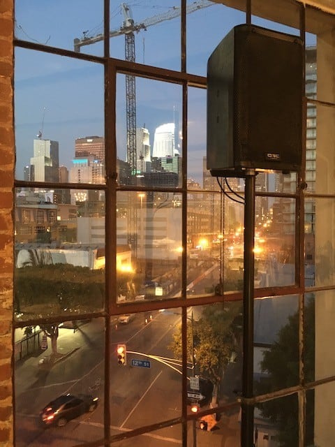 Small speaker on stand in front of window