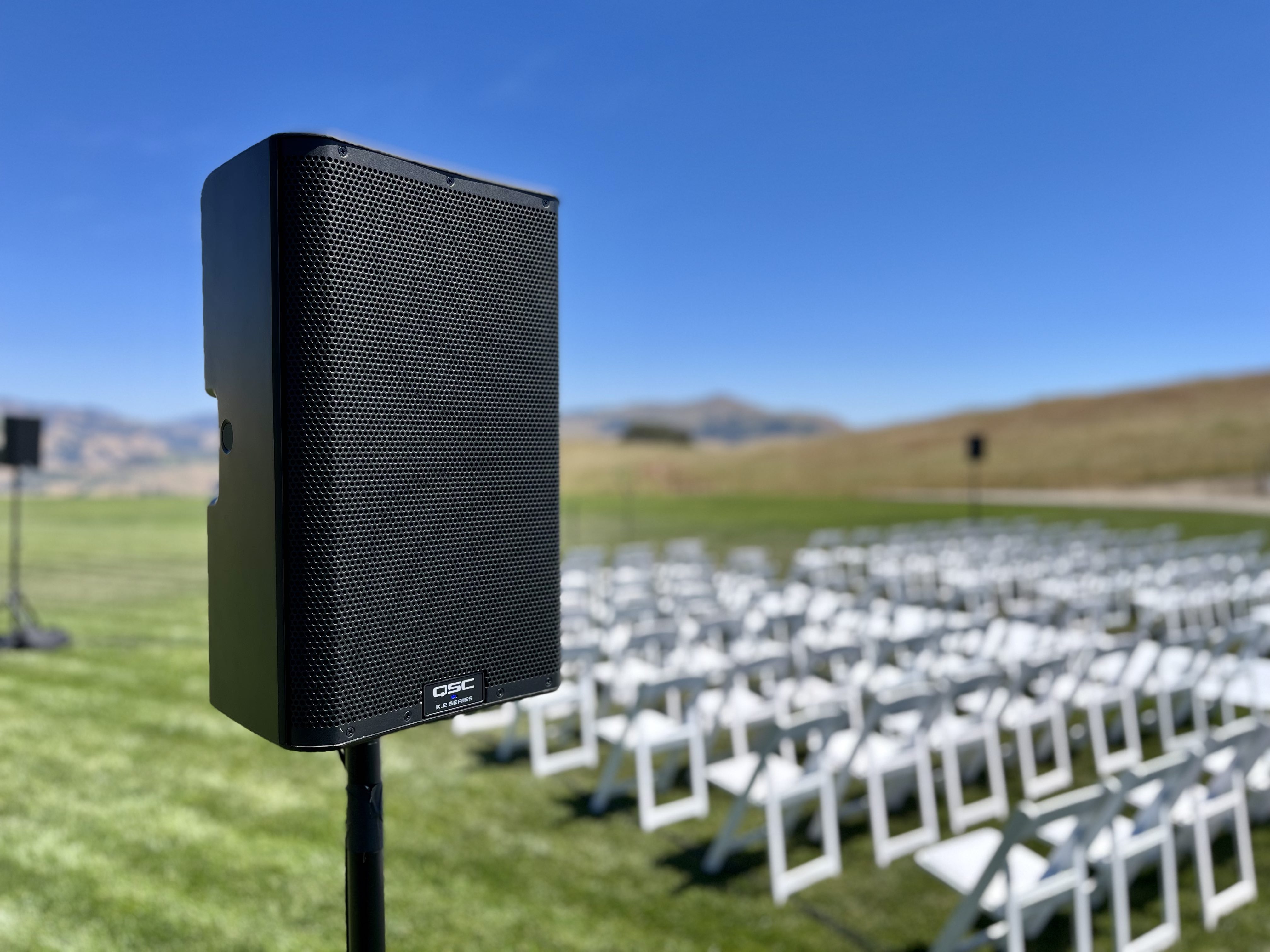 speaker on a stand in front of empty chairs