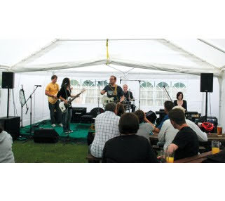 Musicians performing at wedding under a white tent