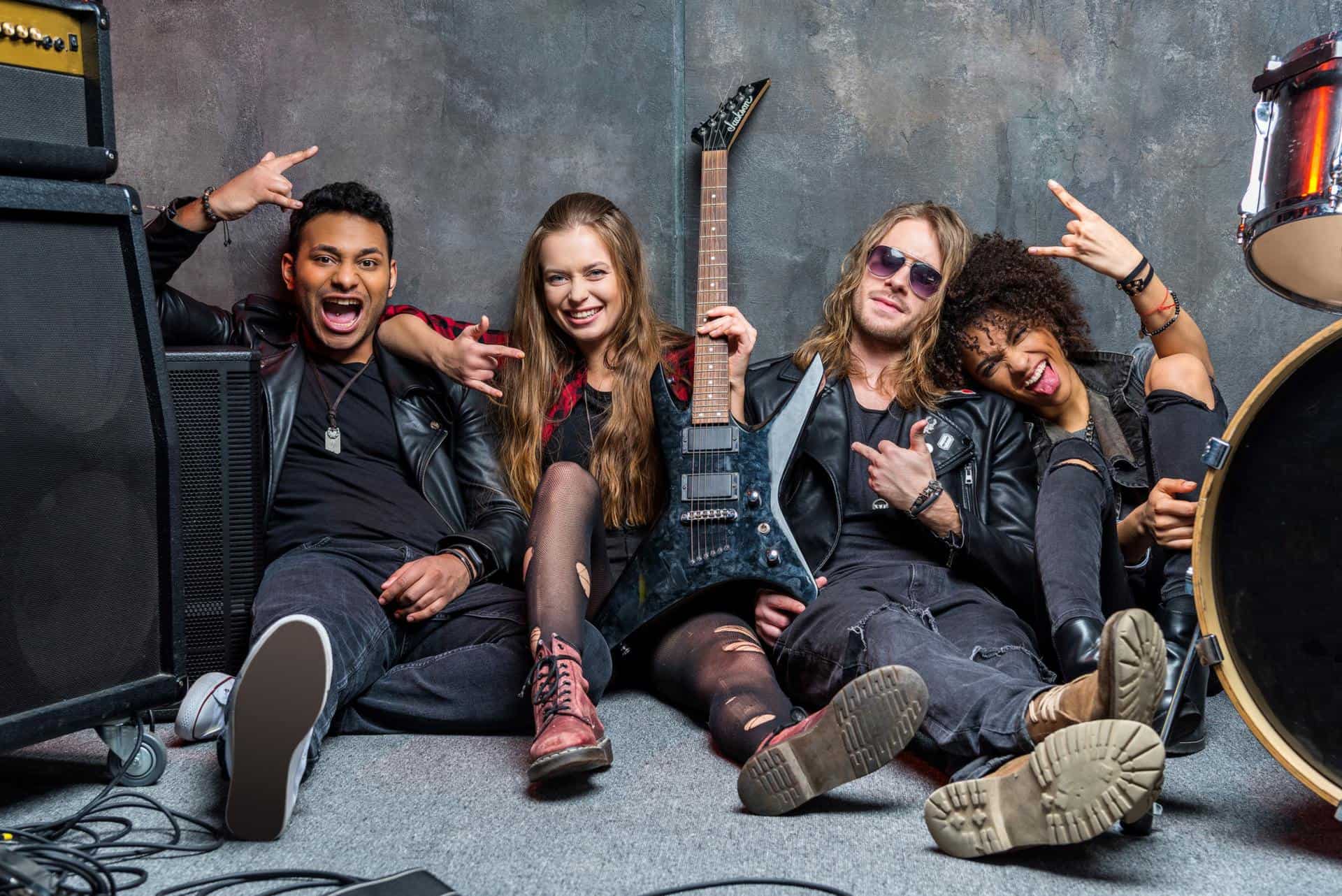 rock band sitting on floor while resting after rehearse in studio